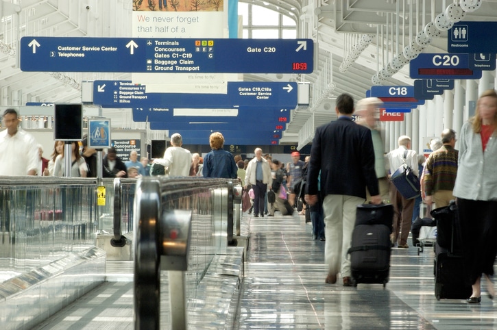 Busy airport and travellers finding terminals