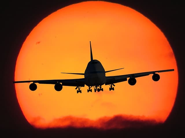 Corporate travel airplane flying at sunset