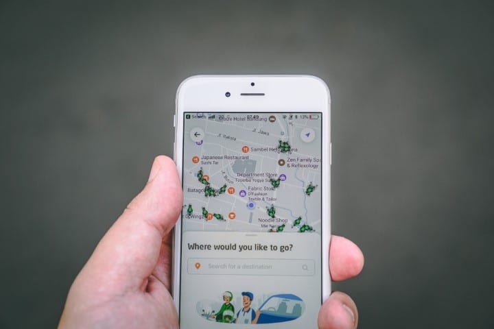Person holding a mobile phone with a ridesharing app