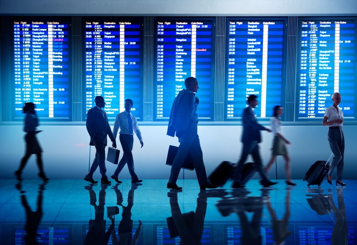 Corporate travellers walking in busy airport 